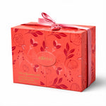 Closed coral floral gift box for Korbaj Her Signature women's scented body care set, tied with a pink satin ribbon.