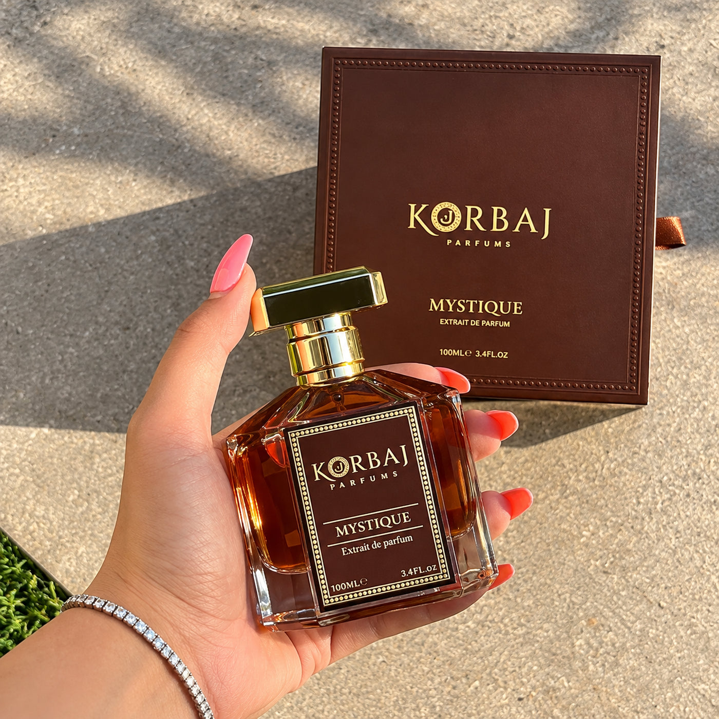 Korbaj Mystique 100ml woody aromatic perfume for men: hand-held bottle in front of an upright brown presentation box.