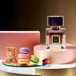 Korbaj Rose Sands 100ml vanilla gourmand perfume for women: bottle and pink box on a pink pedestal with macarons and caramel.
