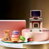 Korbaj Rose Sands 100ml vanilla gourmand perfume for women: bottle and pink box on a pink pedestal with macarons and caramel.